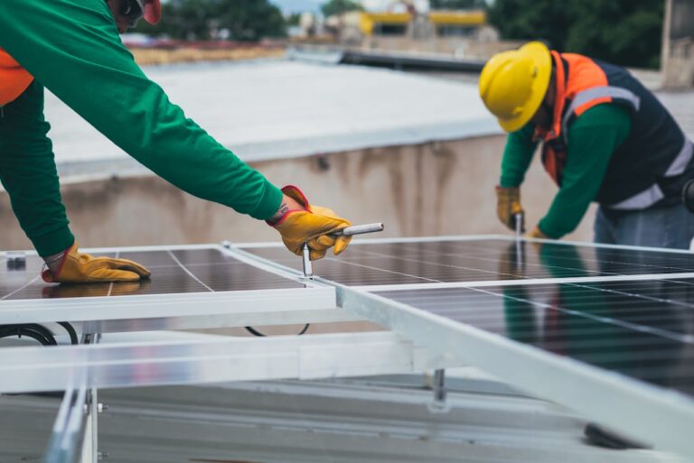 España dice adiós al "impuesto al sol" y da la bienvenida a objetivos más ambiciosos en energías renovables 8 Workers secure solar panels on a rooftop, advancing renewable energy.